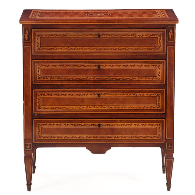 A finely crafted Northern Italian four-drawer commode, circa 1920, richly decorated with intricate parquetry and marquetry...
