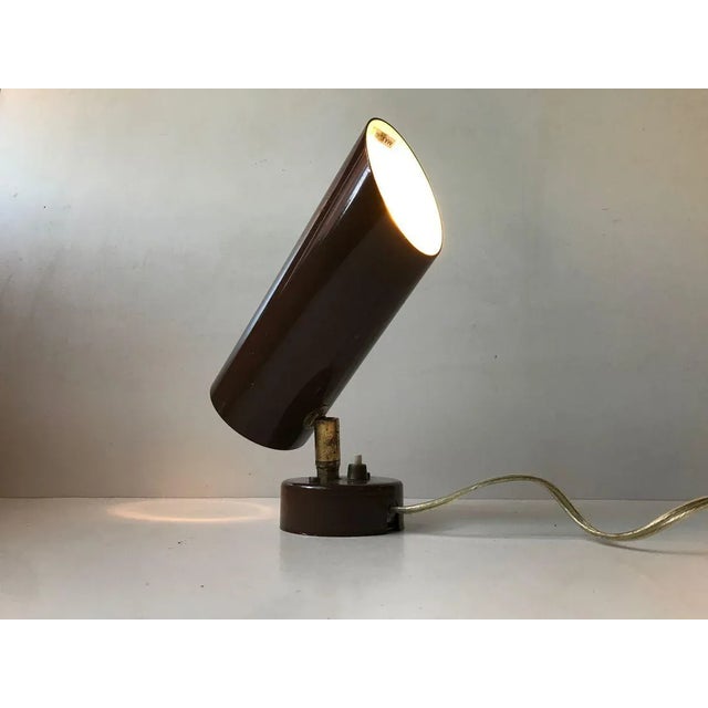 Cylindrical wall lamp composed of brown powder coated aluminium with joint and switch in patinated brass. Anonymous danish...