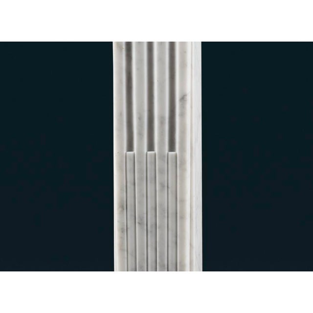 An elegant and petite mid nineteenth-century French Carrara marble fireplace surround in the Louis XVI style, with rope-...