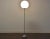 A mid century modern chrome floor lamp with a white globe shade. 12” wide. 12” deep. 55” tall.