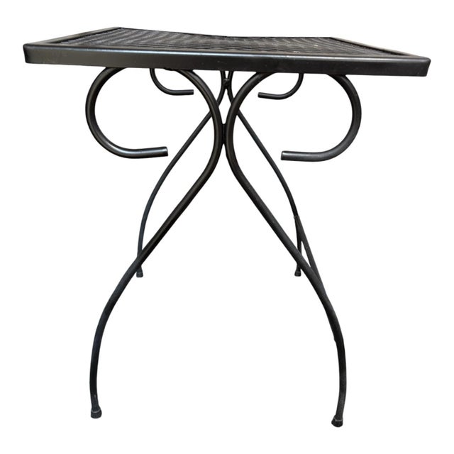 Bring classic mid-century charm to your outdoor or indoor living space with this versatile wrought iron side table....