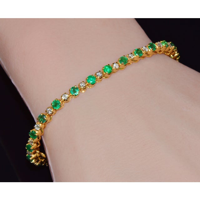 Gorgeous natural 4.90CTS diamond and emerald tennis bracelet crafted in solid 18K yellow gold. This elegant bracelet is...