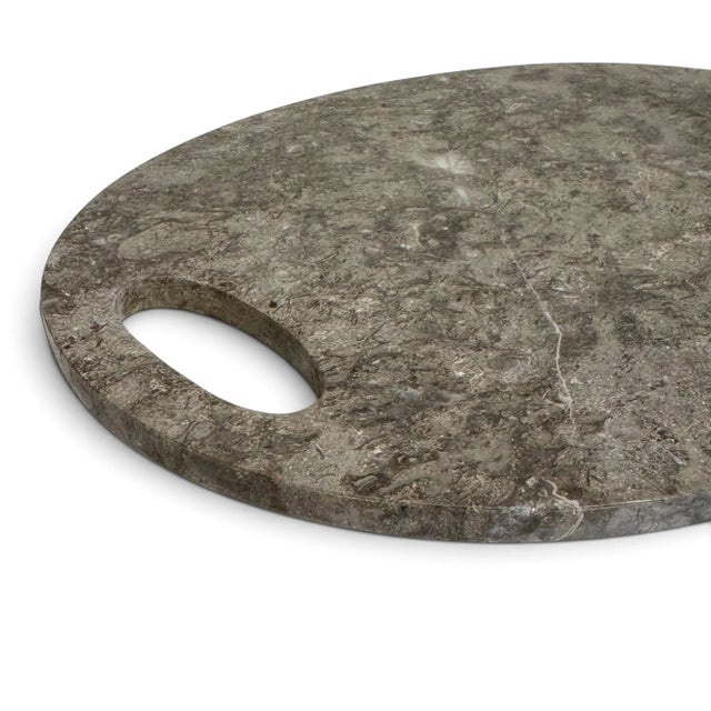 Carved from natural mineral, this oval board is smooth to the touch and rich in gray tones: marbled, veined, and striated...