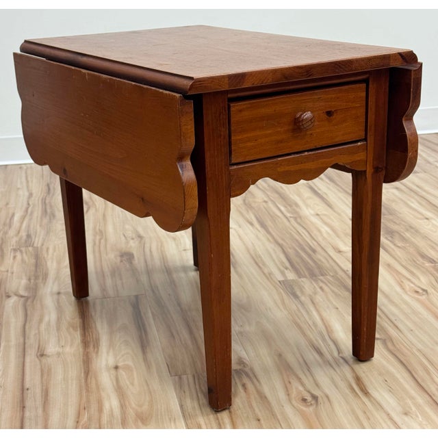 Vintage pine wood drop leaf side table made by Broyhill. Scalloped leaves and apron add charm to this functional piece....