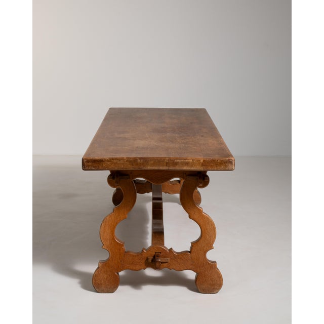 A distinguished example of Spanish ecclesiastical tradition, this early 20th-century refectory table is crafted from rich,...
