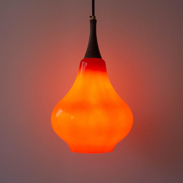 This striking orange glass pendant lamp, crafted in Portugal during the 1960s, is a beautiful example of mid-century...