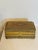 A charming vintage woven metal trinket box featuring intricate filigree-like craftsmanship in warm gold and copper tones....