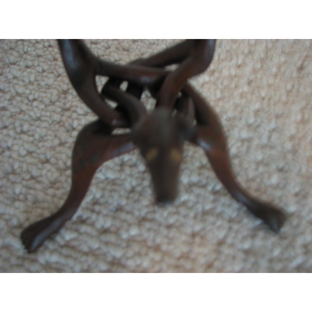 Description A finely carved mid‑20th‑century hardwood serpent tripod stand, crafted from a single block of wood and...