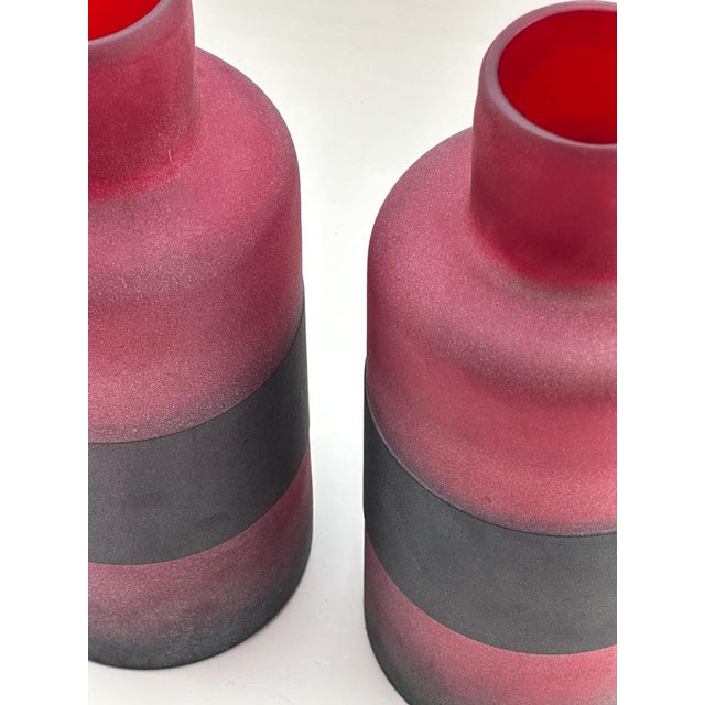 Pair of Murano glass bottles attributed to Cenedese, crafted in Italy circa 1990. Each piece features a cylindrical body...