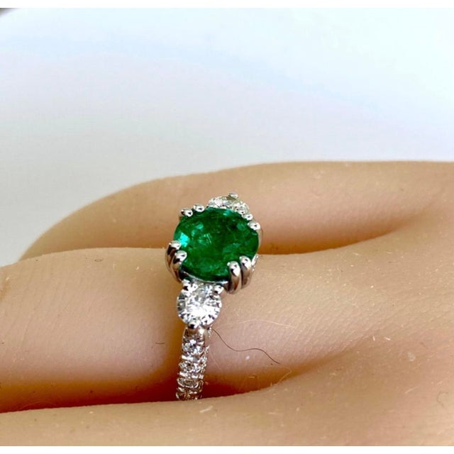 The ring features a captivating design that combines the elegance of 18-karat gold with the natural beauty of a round...