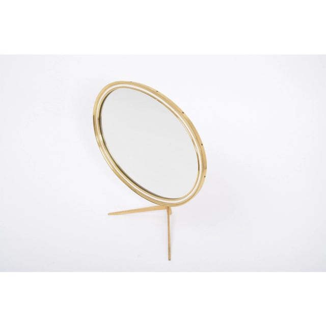This mid century modern table mirror features a solid brass stand and frame. The mirror can be adjusted to the desired...