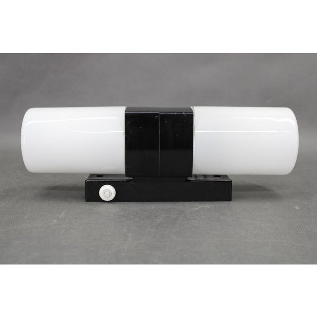 Elegant mid century wall light manufactured in czechoslovakia in the 1960s, showcasing a refined combination of black...