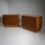 Pair of two-door wooden sideboards with clean-lined, plinth-based bodies. The doors are structured with irregular rows of...