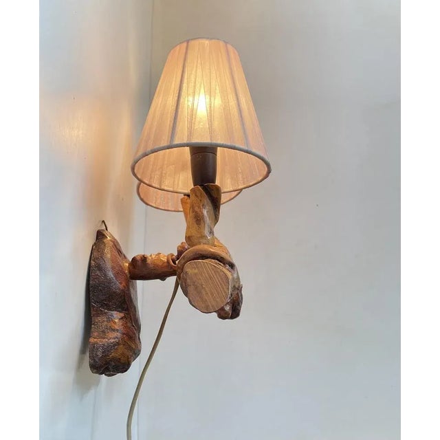 Unusual live-edge dual wall sconces fashioned from old vine wood. It features pink textile period shades and bakelite...