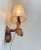 Unusual live-edge dual wall sconces fashioned from old vine wood. It features pink textile period shades and bakelite...