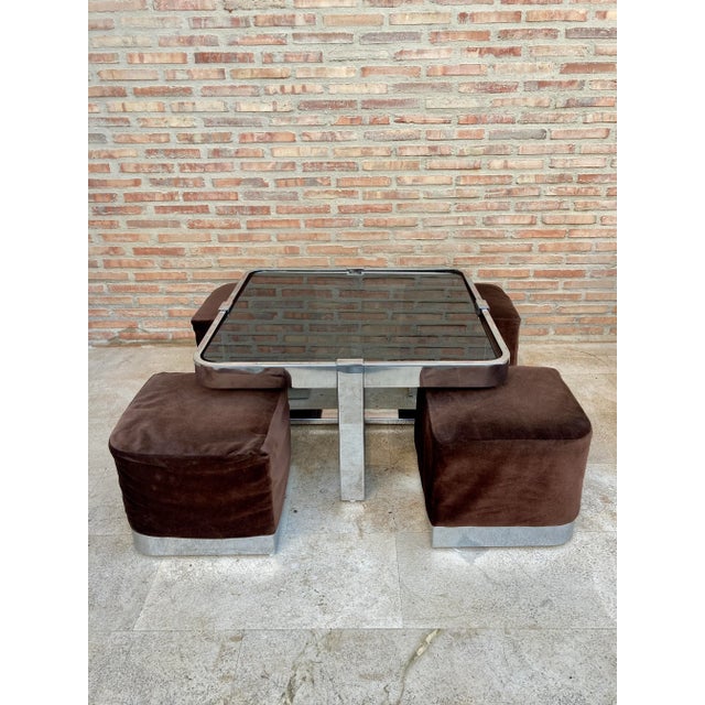 Vintage square smoked glass and steel coffee table with four nesting stools, recently upholstered in white leather. A...