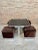 Vintage square smoked glass and steel coffee table with four nesting stools, recently upholstered in white leather. A...