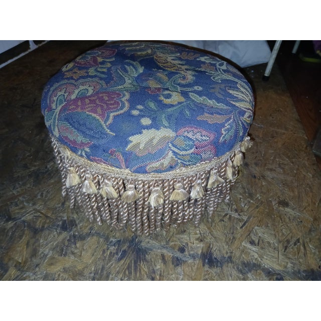 Super cute little vintage blue floral Paisley ottoman with gold Fringe. Very cushy and comfortable. Button accent in...