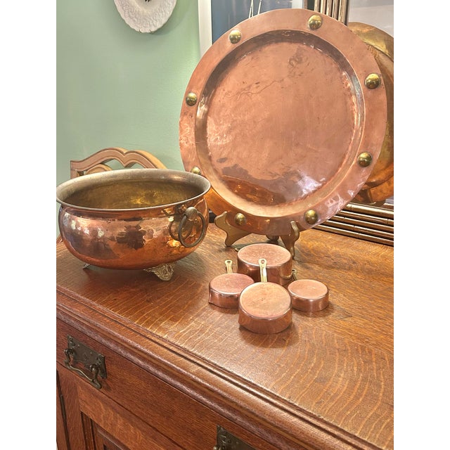 A timeworn set of vintage copper measuring cups, rich with patina and old-world charm. Crafted with solid copper bodies...