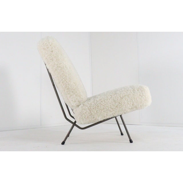 This armchair fits perfectly within the Mid-Century Modern style. The design features a sleek gray lacquered metal frame,...