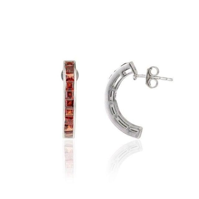 Crafted in 925 sterling silver, these garnet channel set hoop earrings feature a sleek arrangement of square-cut garnet...