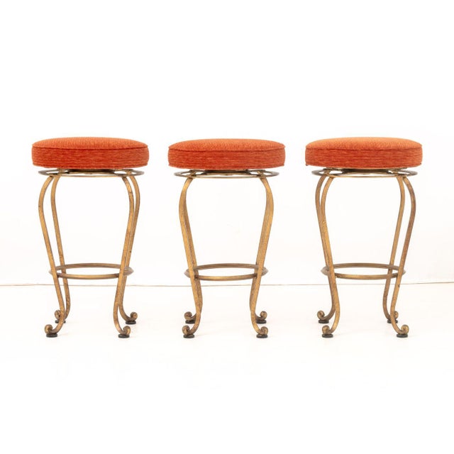 Set of Three Modern Orange Corduroy Upholstered Swivel Stools, with gilt metal scrollwork bases. 27" H x 16" Diameter....