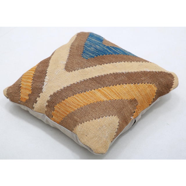 A one-of-a-kind handwoven Afghan wool kilim accent pillow featuring bold V-chevron bands in slate-blue, gold and brown on...