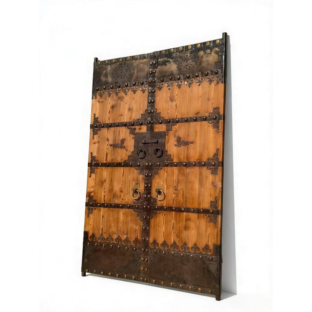 This pair of 19th century Chinese door panels showcase a masterful blend of rustic wood and hand-forged ironwork. With...
