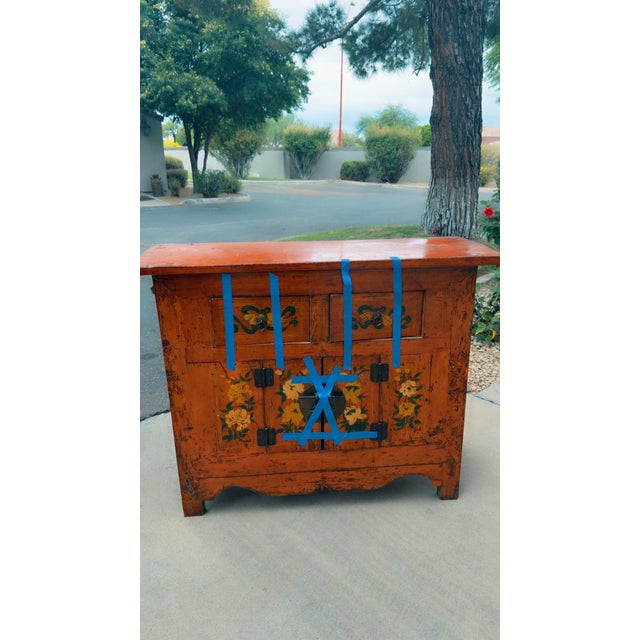 Antique Chinese Qing Dynasty cabinet, crafted from elm wood, and finished in a distressed lacquered orange It features two...