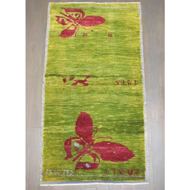 A Turkish Anatolian green color rug with a butterfly design dated 1975