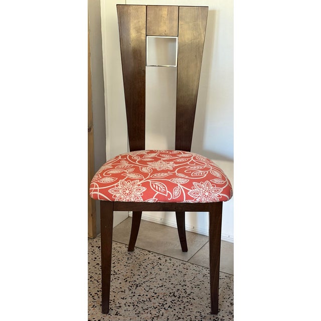 This contemporary dining chair features a distinctive slotback design paired with a vibrant red and white floral patterned...