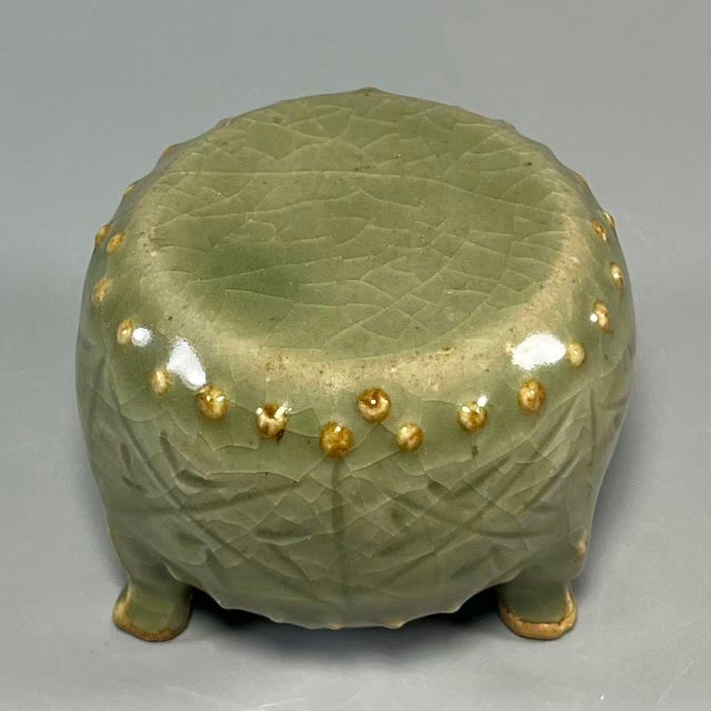 This is a rare Chinese Longquan celadon tripod vessel. It features crackled celadon glaze, adorned with moulded geometric...