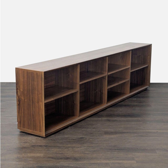This Room and Board bookshelf features a sleek, low-profile design with a natural walnut wood finish. It offers adjustable...