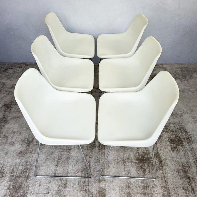 Set of six white moulded polypropylene chairs with chrome sled bases, designed by Robin Day for Hille. The contoured...