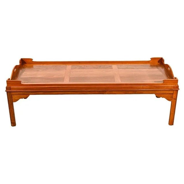 This English hand carved tray top coffee table features a finely crafted wooden frame with raised edges and cut-out...