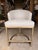 Elevate your dining space with this contemporary counter stool, featuring a softly textured ivory upholstery paired with a...