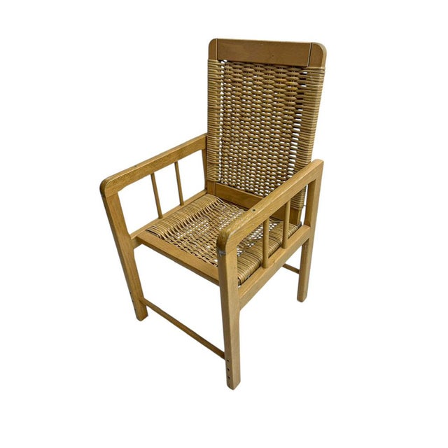 Characterful armchair for children, made from beech wood with subtile vertical slats and a woven wicker seat and backrest....