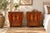 Two small cabinets in worn red lacquer stand side by side, their double doors painted with gilt decoration that has...