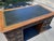 This Vintage Sligh Furniture Leather Top Executive Desk is a stunning piece from the 1960s, showcasing an antique brass...