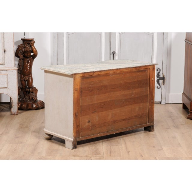 A Swedish Baroque style serpentine front three-drawer chest from the 19th century with light gray painted finish,...