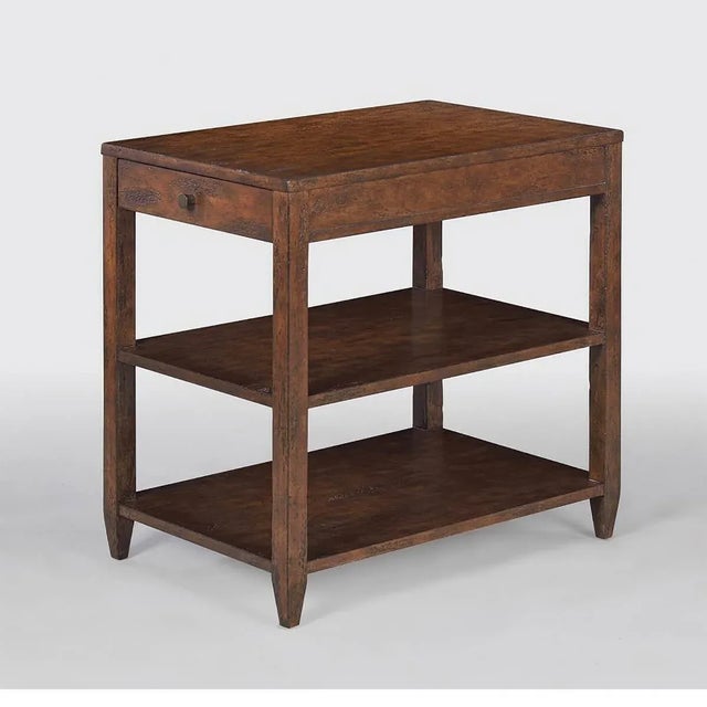 Classic narrow rectangle side table with a drawer, two shelves, brass hardware, and tapered teen, has a “country” mahogany...