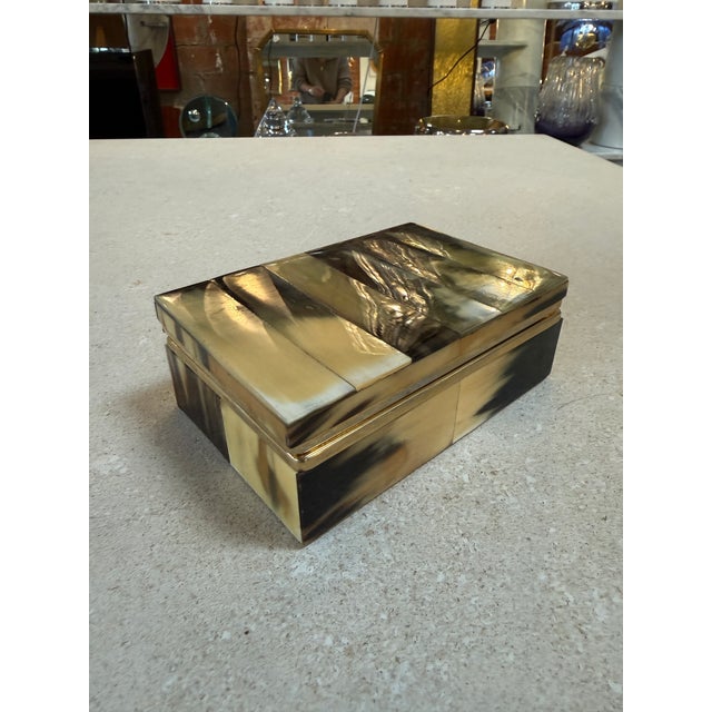 Elegant vintage jewelry box featuring a striking natural horn veneer in rich tones of cream, amber, and deep brown. The...