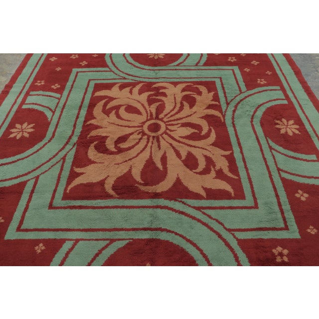 Hand-knotted in wool circa 1920-1930, this 8x9 antique French Art Deco rug enjoys a bold geometric design with floral...