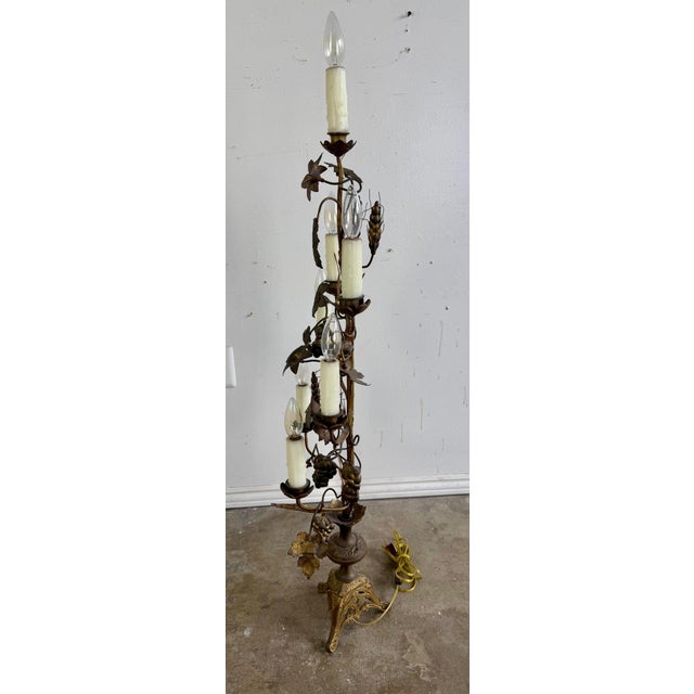 Pair of ornate Italian candelabra-style lights. They feature metal framework with intricate floral and grapevine motifs,...