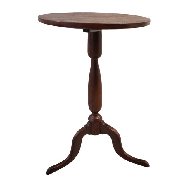 A handsome mid-19th century American solid walnut candle stand featuring a circular one-board top raised on a finely...