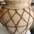 A hand made Papier mache urn. Very decorative with a great nubby texture. The vase is encased in a rawhide basket.