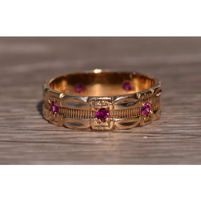 The Smithwick: Retro Era Rose Gold and Ruby and Pink Sapphire Eternity Band. Set in the center of this band are...