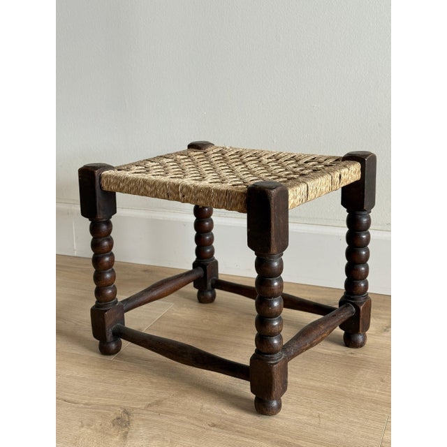 This English rush-seated stool features a tightly woven square seat in natural fiber over a sturdy oak frame. The turned...
