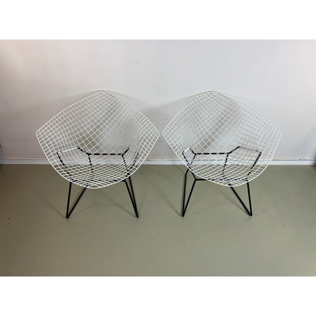 Two original Diamond Chairs by Harry Bertoia for Knoll, one in black and one in white. Original receipt included. A mid-...