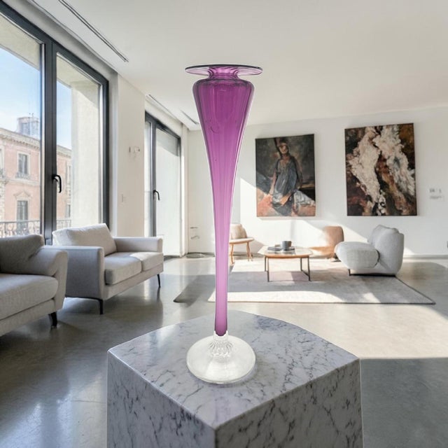 A signed studio art glass trumpet bud vase by Young & Constantin, model 109917, executed in a vivid ruby tone with a...